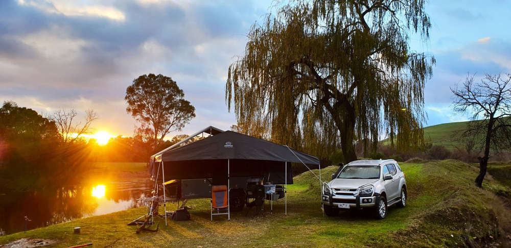 camper trailer and car on a river bank